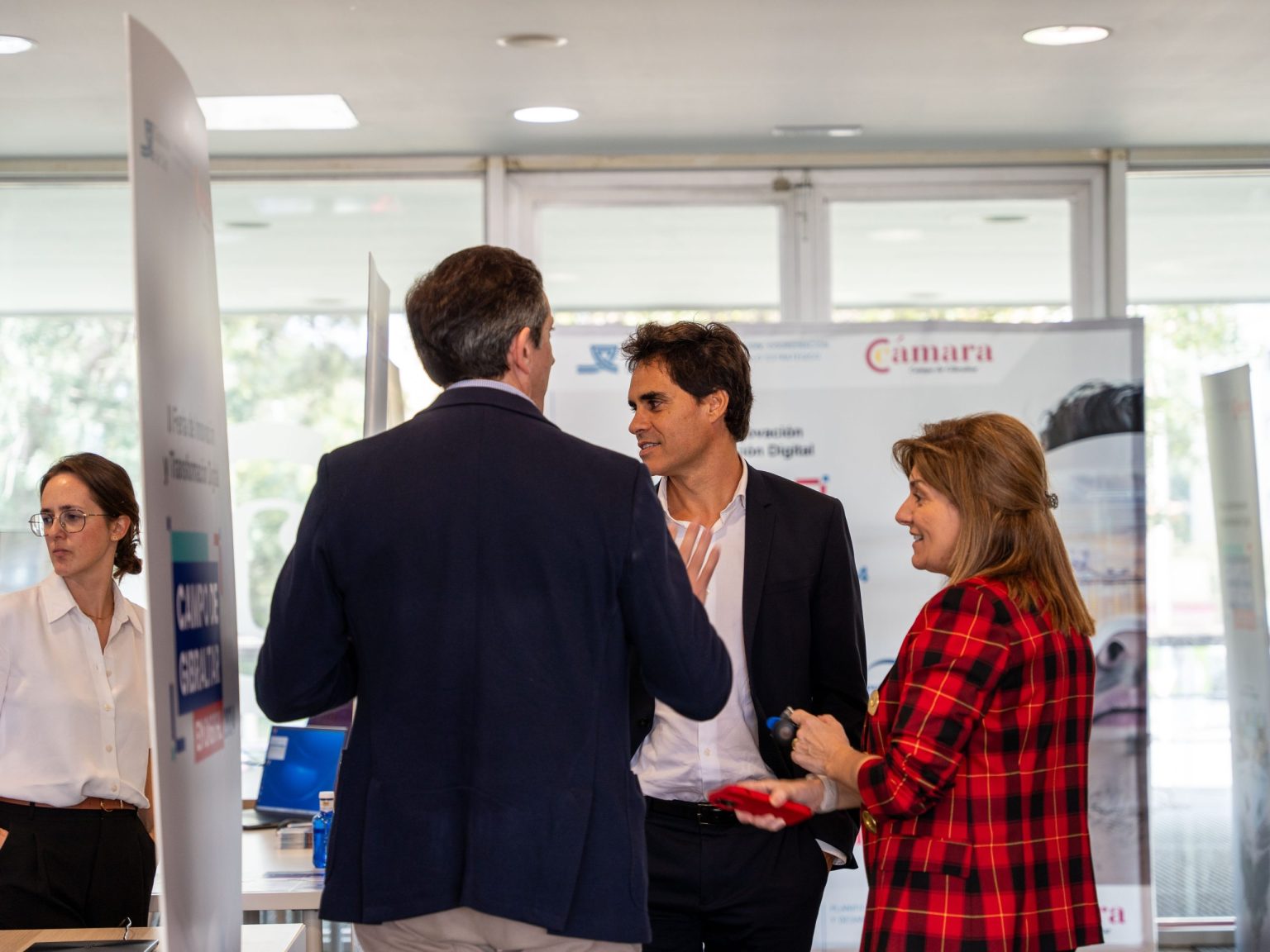 Intercambio de ideas entre asistentes en el stand de la Cámara de Comercio durante la Feria Campo de Gibraltar en Digital 2024